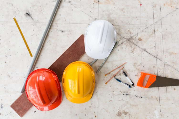 Construction equipment safety helmet, saw, nut and other construction tools on the working table.